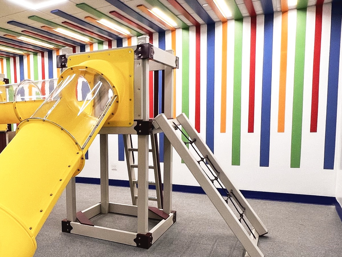 Gym with climbing wall, sensory swing, and balance equipment